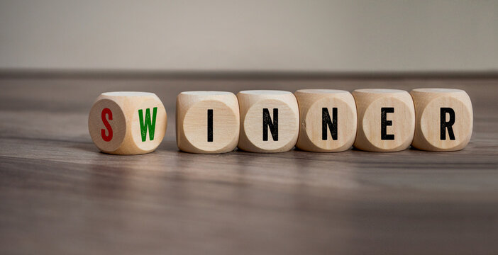 Cubes, dice or blocks with words from sinner and winner on wooden background 