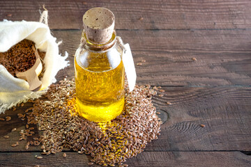 Flax seeds and a bottle of linseed oil on a wooden background. An alternative source of omega 3 vitamins and fats