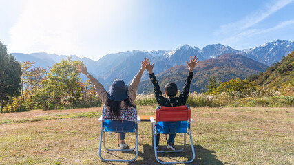 Mountain traveler couple relaxing, take it easy enjoying tourist adventure mountaintop travel freedom, mountaineering height of outdoor hill top trip with panoramic view of nature peak and sky horizon
