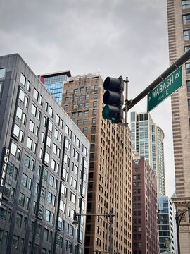 chicago cityscape with a view of downtown buildings with a traffic light in the air on a cloudy winter day
