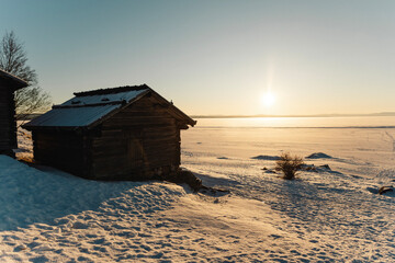 Wooden cabin at frozen like in Sweden in sunset