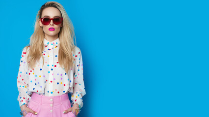 Young woman, blonde hair woman wearing sunglasses, retro style concept, blue solid background, banner, copy space