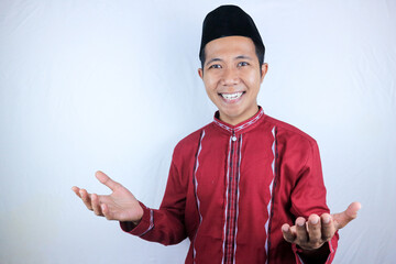 Smiling of excited muslim asian man wearing cap with open hand gesture
