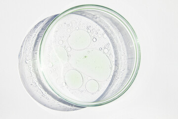 Petri dish. Petri cups with liquid. Kit. Chemical elements, oil, cosmetics. Gel, water, molecules, viruses. Close-up. On a white background.