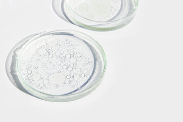 Petri dish. Petri cups with liquid. Kit. Chemical elements, oil, cosmetics. Gel, water, molecules, viruses. Close-up. On a white background.