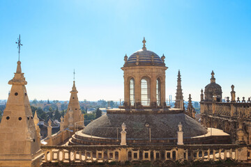 View from the Giralda Tower out over the roof and spires of the Seville cathedral with the city in...