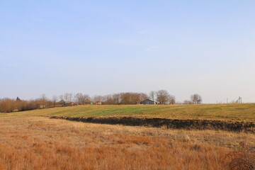A field with a house in the distance