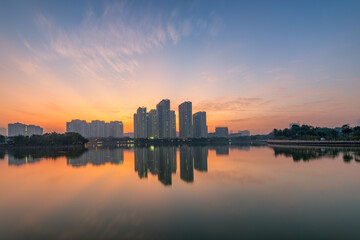 Fototapeta premium Buildings with reflections on lake at sunset at An Binh City, Hanoi.
