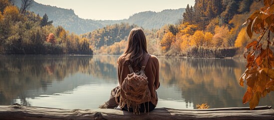 Contemplative Woman Sitting on a Log Enjoying Serenity by the Lake - obrazy, fototapety, plakaty