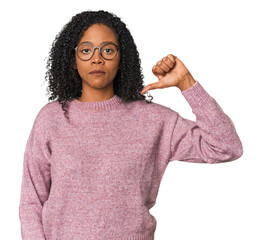 African American woman in studio setting showing a dislike gesture, thumbs down. Disagreement...