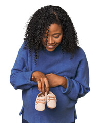 Obraz premium Pregnant African American woman with baby shoes
