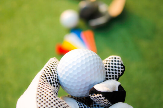 Hold the golf ball with the golf glove on your left hand.