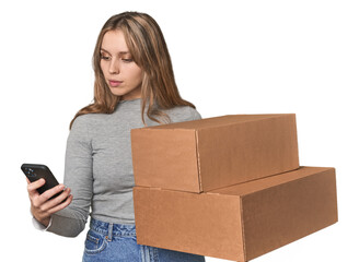 Caucasian blonde with boxes and phone, coordinating move with an app .