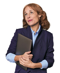 Mid-aged Caucasian with laptop in studio dreaming of achieving goals and purposes