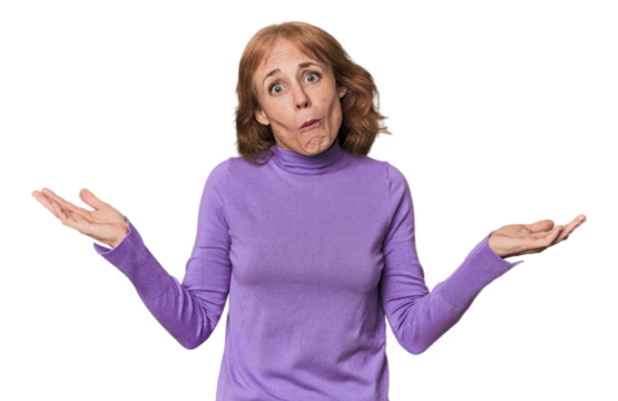 Redhead mid-aged Caucasian woman in studio doubting and shrugging shoulders in questioning gesture.
