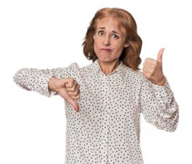 Redhead mid-aged Caucasian woman in studio showing thumbs up and thumbs down, difficult choose concept