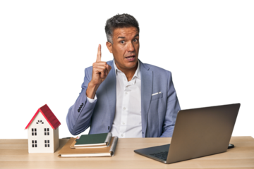 Middle-aged Hispanic businessman with real estate theme having an idea, inspiration concept.