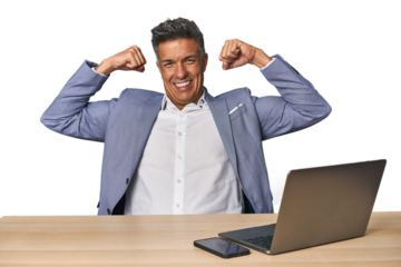 Elegant businessman at desk with laptop showing strength gesture with arms, symbol of feminine power