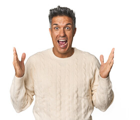 Fototapeta premium Middle-aged Latino man celebrating a victory or success, he is surprised and shocked.