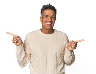 Middle-aged Latino man pointing to different copy spaces, choosing one of them, showing with finger.