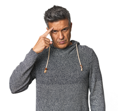 Middle-aged Latino man pointing temple with finger, thinking, focused on a task.