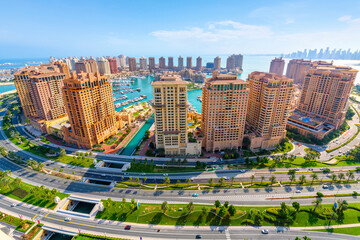 High angle panoramic wide view of the Doha Pearl Island in Doha, Qatar, an artificial island filled with residential and commercial buildings along the Persian Gulf.
