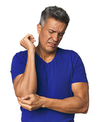 Middle-aged Latino man massaging elbow, suffering after a bad movement.