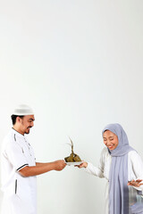 Asian MUslim Female and Male Holding White Plate with Ketupat for Eid Mubarak Celebration