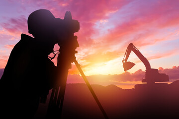Silhouette surveyor. Man with geodetic instrument at sunset. Surveyor works at construction site. Engineer with equipment for geodetic research. Surveyor engineer near excavator. Guy with theodolite - obrazy, fototapety, plakaty