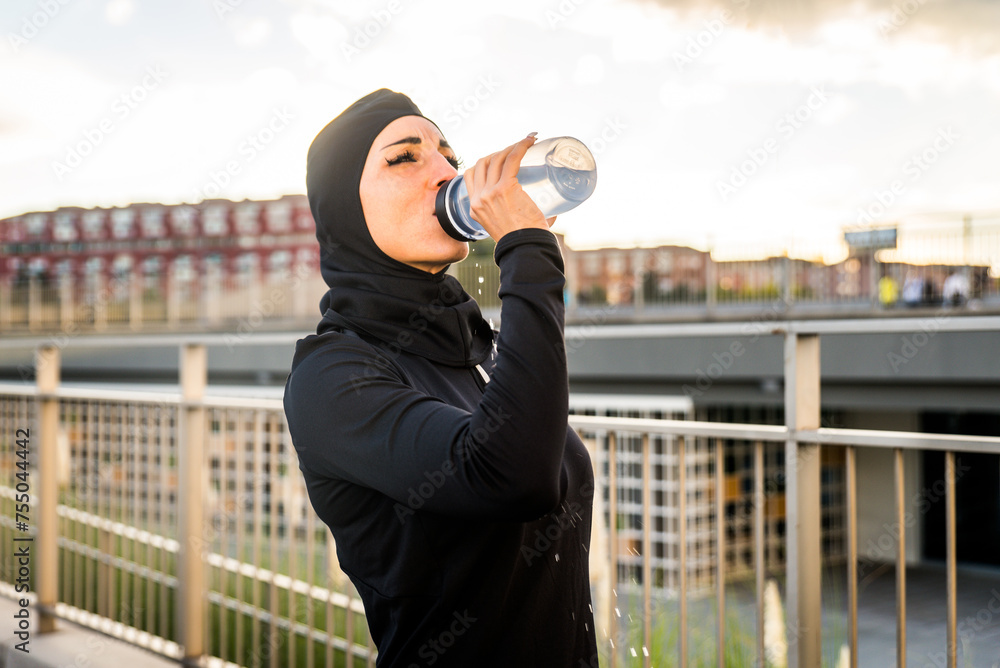 Wall mural Arab middle-eastern woman doing sport workout training outdoors in a urban area