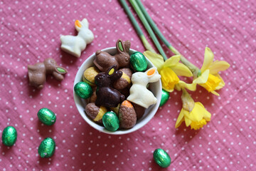Milk chocolate bunny and eggs on a table. Bright and colorful Easter card. 
