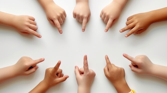 The hands of a child point at a white background, top view