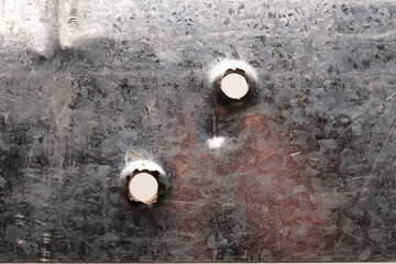 Bullet holes on gray sheet metal, close-up