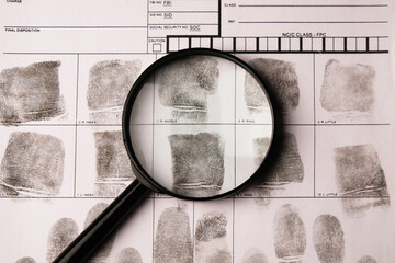 Fingerprints on a fingerprint card and a magnifying glass, fingerprint examination
