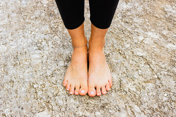 Closeup feet of young woman practicing yoga in the mountains. Grounding and training outdoors. Harmony, balance, relaxation and healthy lifestyle.