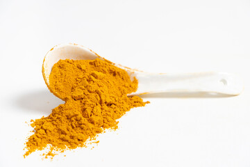 Scattered turmeric powder on white background, turmeric pattern and texture