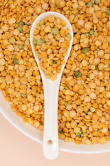 Pea yellow groats grains cereal in spoon close-up macro.