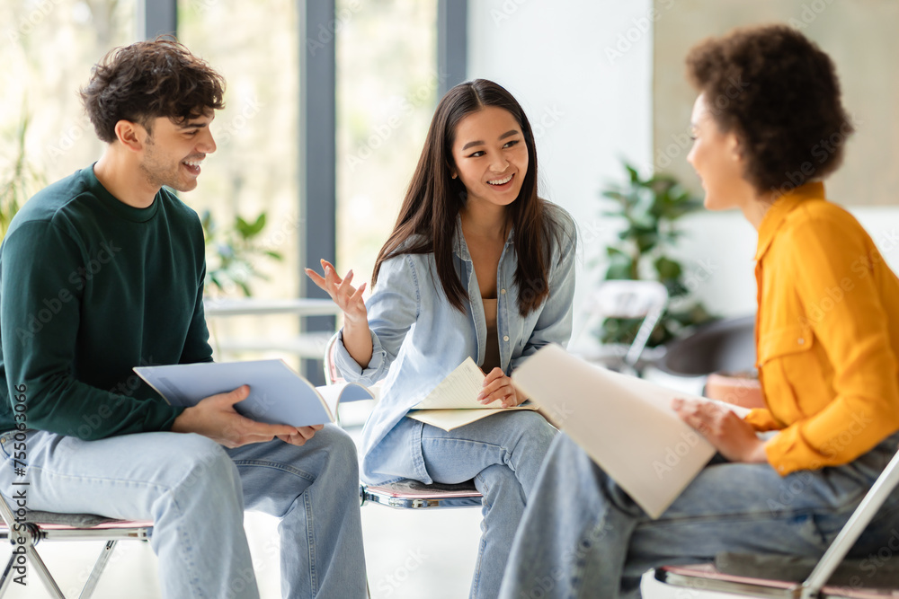 Poster multiracial students discussing notes in lively group study session
