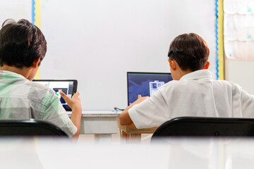 Elementary child using a laptops in a classroom.