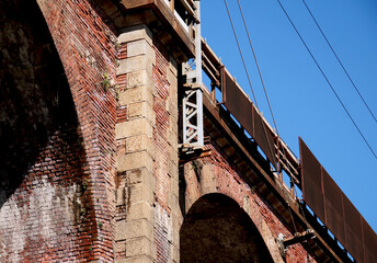 A solid red brick railway bridge with structural details linked to the surface power supply - 755064452