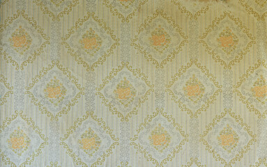 Old wallpaper on the wall. Old wallpaper for texture or background.
