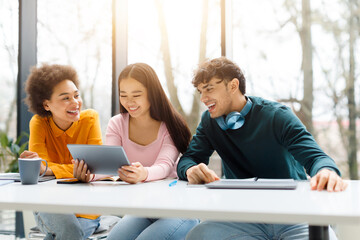 Cheerful diverse students with tablet and coffee