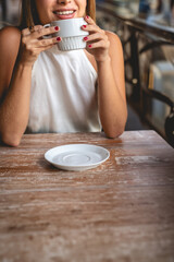 Casual coffee break from work in a outdoor city coffee: beautiful and relaxed blonde latina executive sipping coffee in a scenic city spot (big copy space)