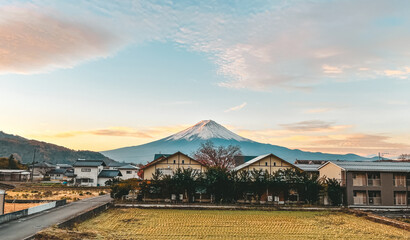 A mountain is in the background of a town with houses and a road - obrazy, fototapety, plakaty