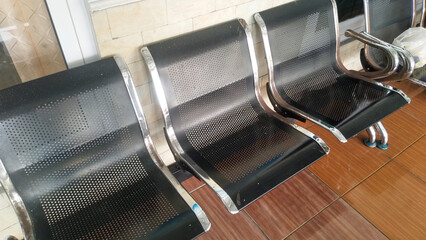 Empty chairs in airport terminal waiting area with sunlight in the outdoor.