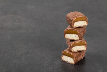 Cookies with caramel in chocolate glaze. In the section. Dark background. Copy space