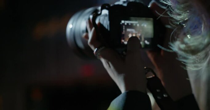 A close-up of the camera display of a photographer who takes pictures during a fashion show of a women's collection in a dark room. Fashion Week, the work of photographers at a fashion show. 4k