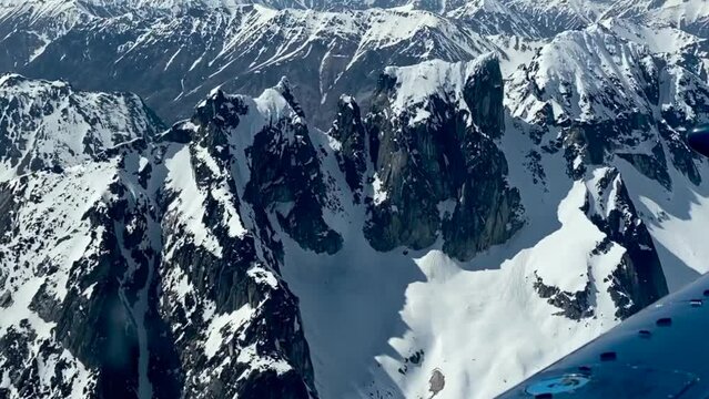Beechcraft Bonanza airplane wingtip flies over Lake Clark Pass in Alaska. Mount Redoubt in the background. Small aircraft are only way to see many areas of Alaska.