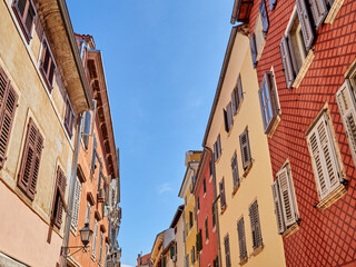 Fototapeta na wymiar Colourful facades over a bright blue sky in a summer day in Rovinj, a touristic charming village in Istria. Croatia, Europe