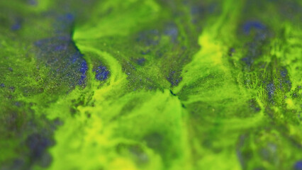 Acid paint. Neon fluid mix. Defocused bright green yellow blue color shimmering texture ink blend...